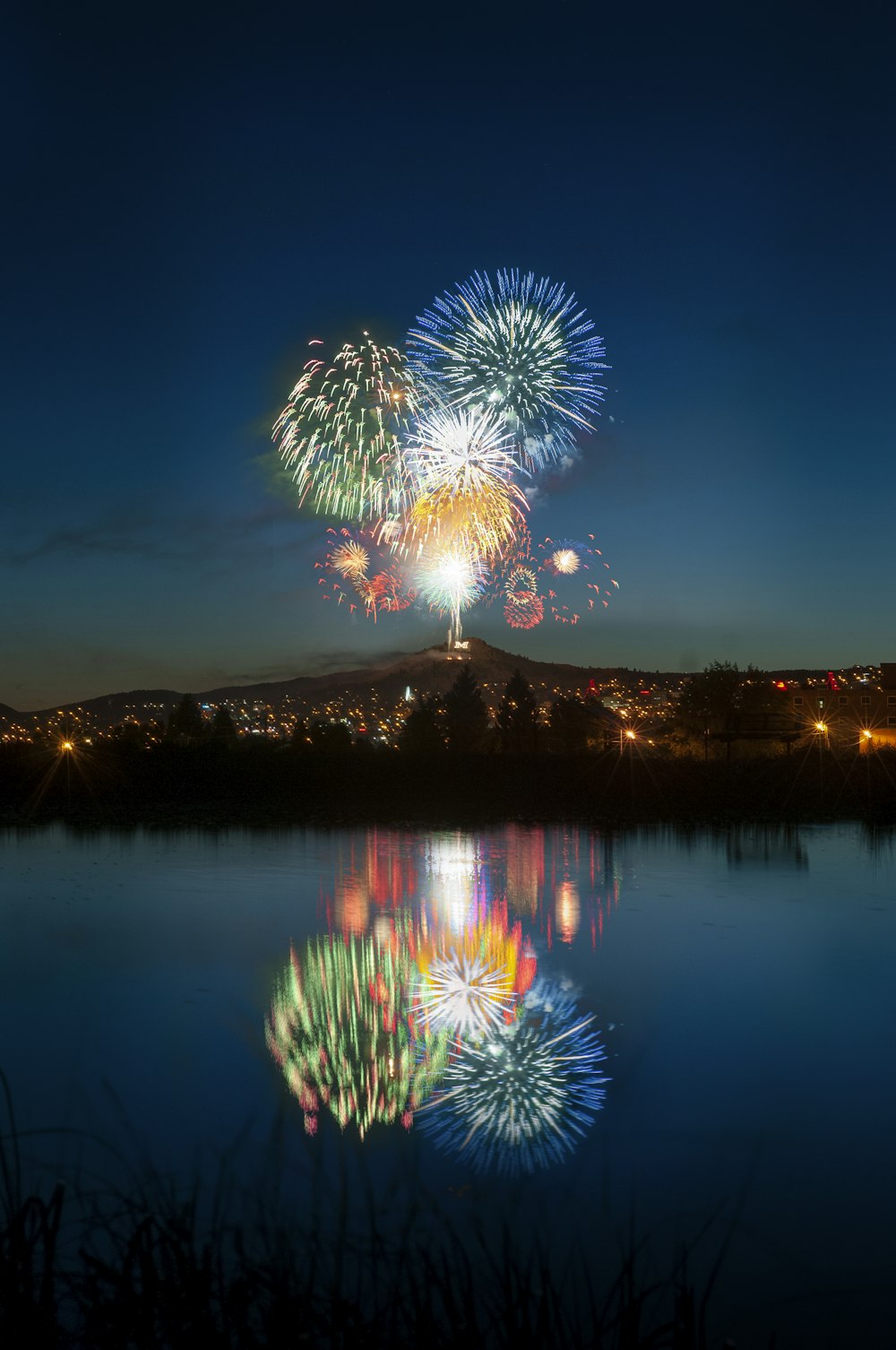 fireworks in the sky over a lake