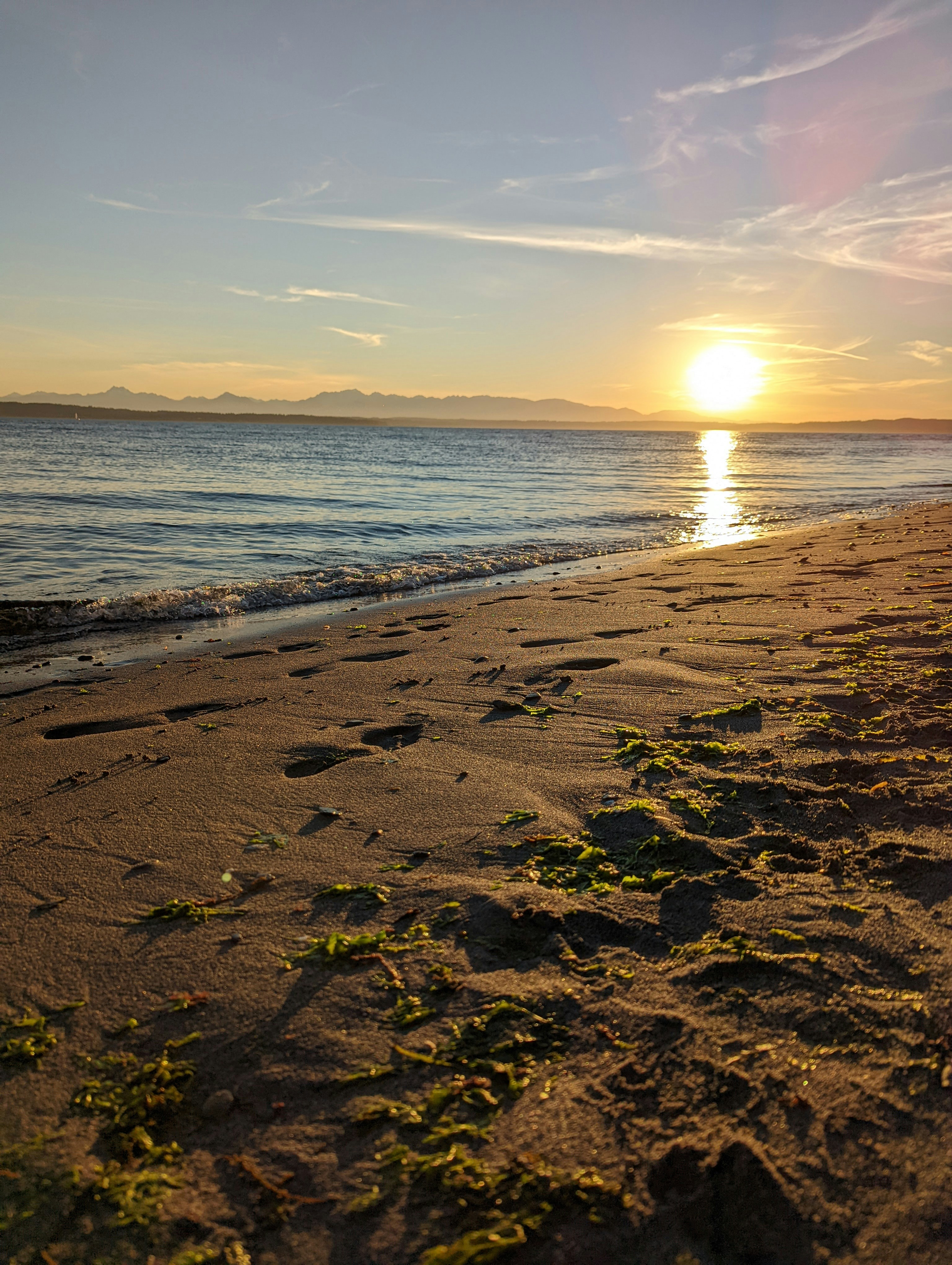 a beach with the sun setting
