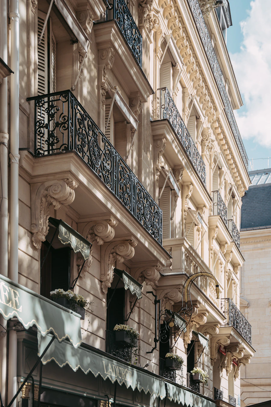 Immeuble haussmannien avec balcons ornés, façade en pierre grise
