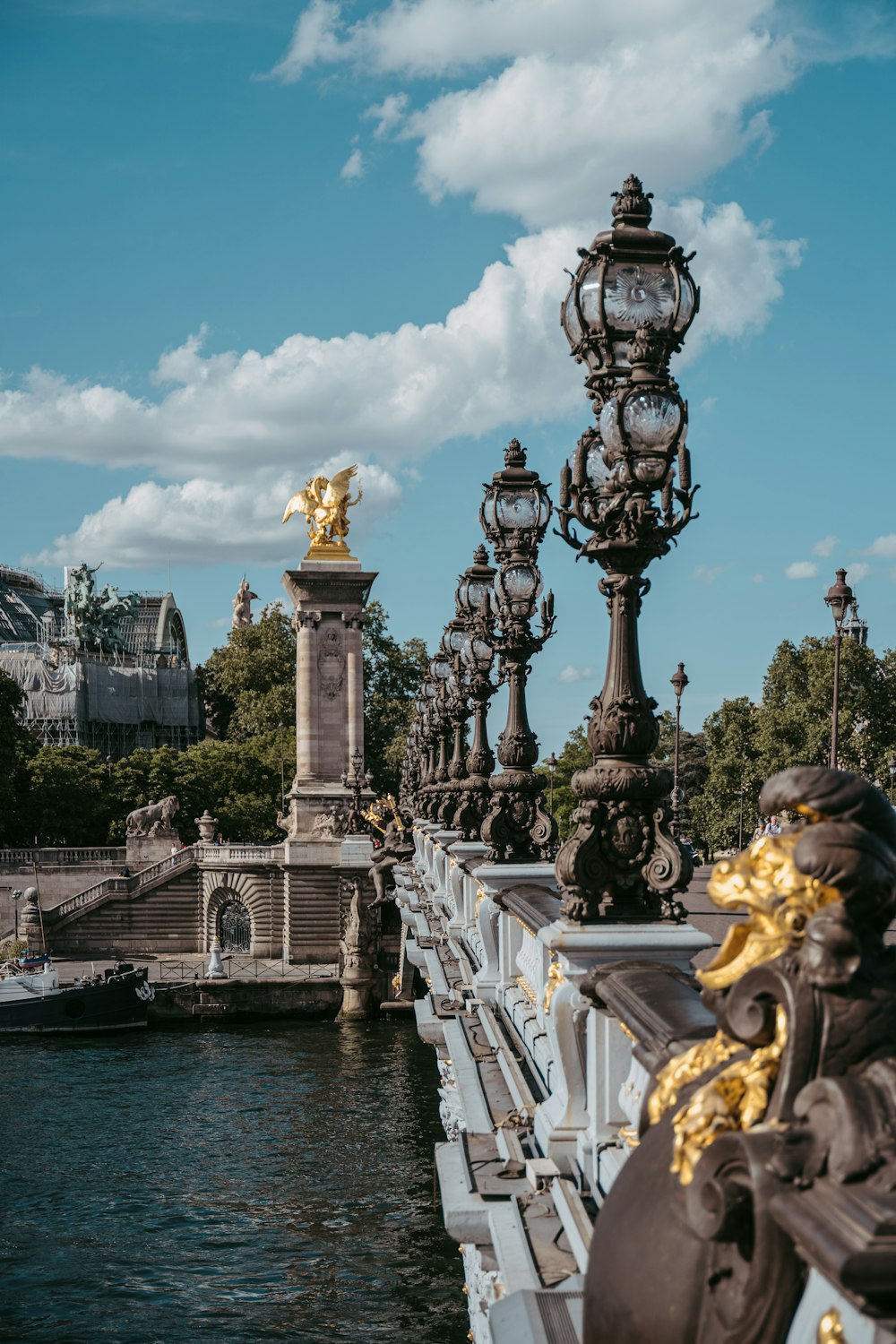 Pont Alexandre III con una estatua y un cuerpo de agua en el fondo