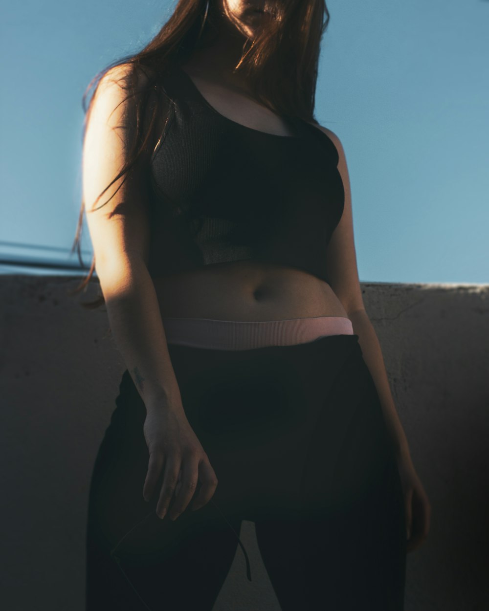 Foto Una mujer con un top negro y leggings negros – Moda Imagen en Unsplash