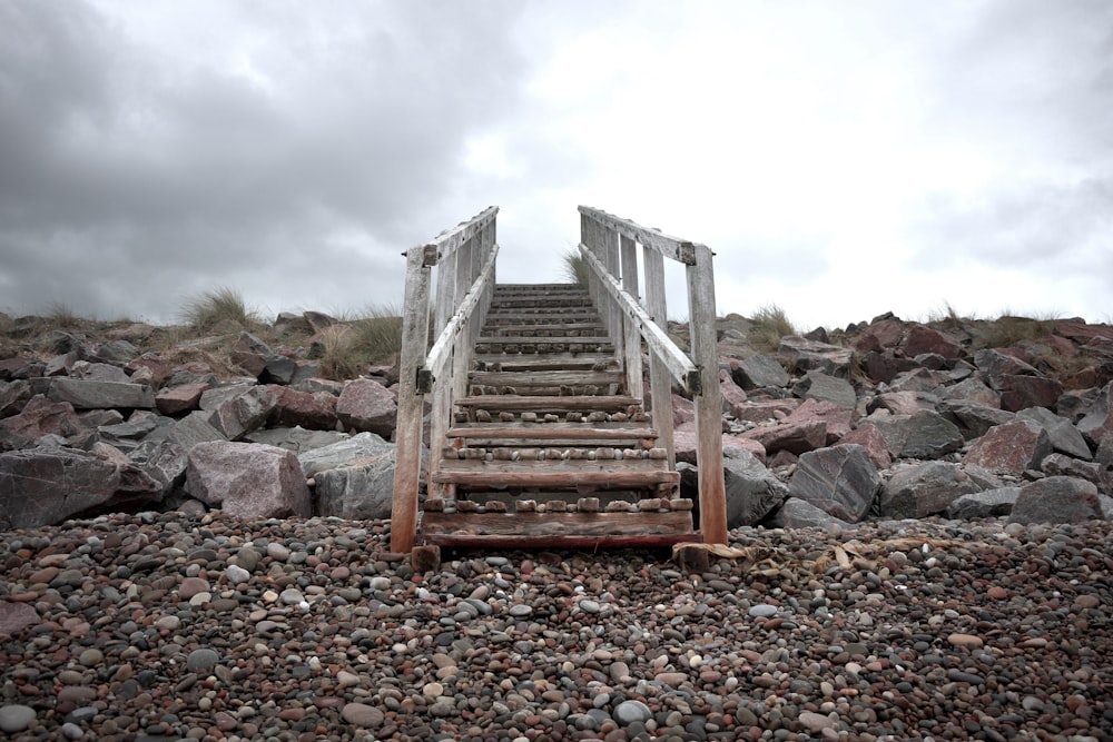 a wooden bench on a rocky beach