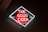 A neon sign with the text 'THE GOOD CIDER' in bright red, surrounded by a white neon outline. The sign is mounted on a dark wall and includes additional text 'Since 1918' and 'OF SAN SEBASTIAN'. The overall glow of the neon creates a vibrant and inviting atmosphere.