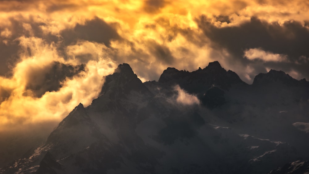 a mountain with clouds above it