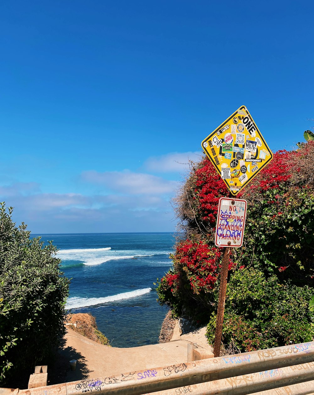 a sign on a path by the ocean