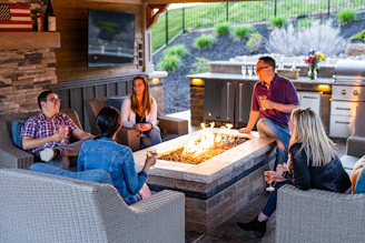 a group of people sitting around a table with a fire in it