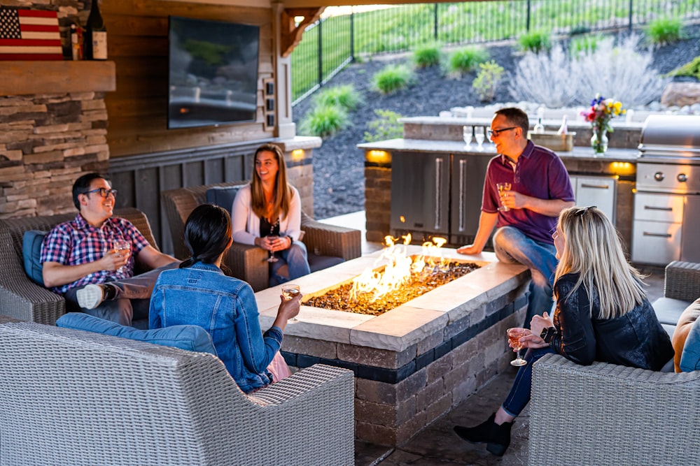 a group of people sitting around a table with a fire in it