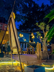 A custom container cafe with outdoor seating and decorative lighting at dusk.