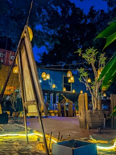 A custom container cafe with outdoor seating and decorative lighting at dusk.