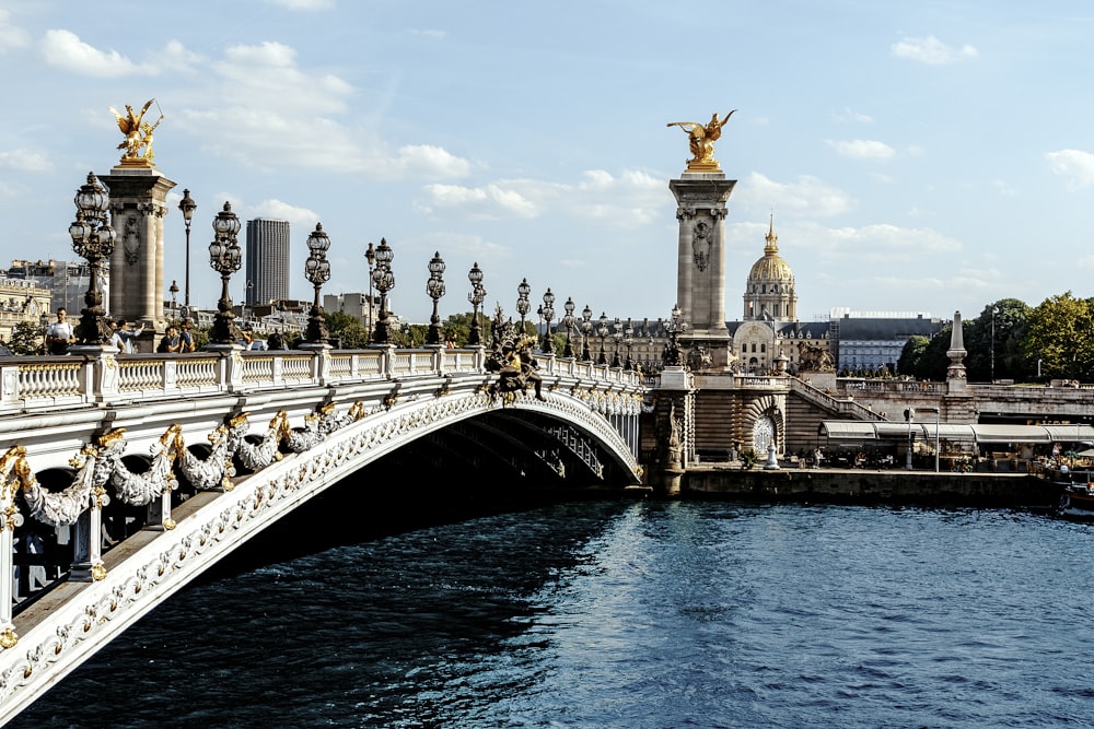 a bridge over a body of water with a statue on top