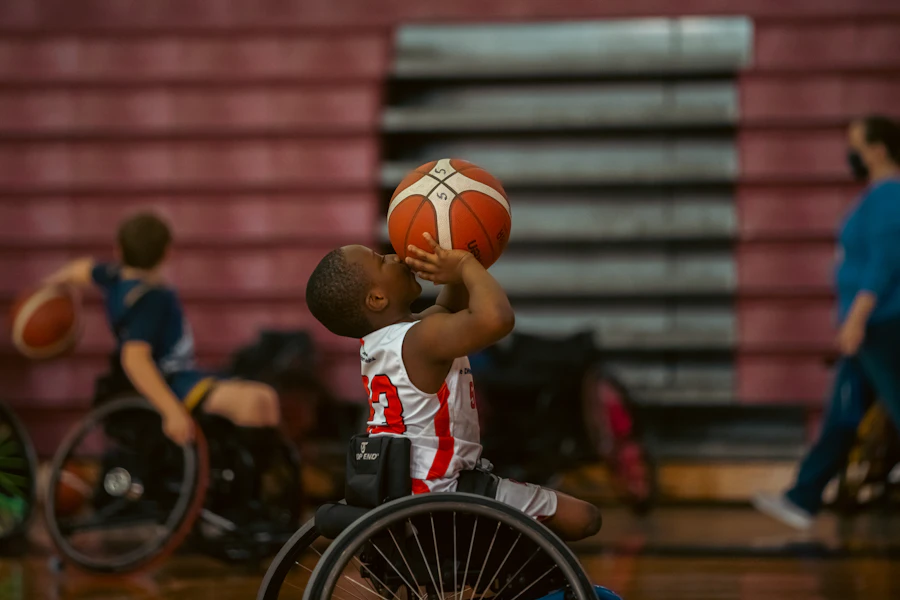 Niño en silla de ruedas practicando baloncesto