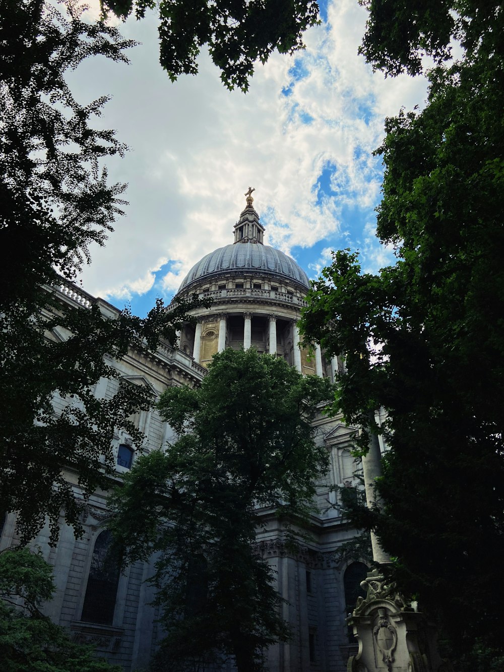 a building with a dome and trees in front of it