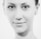 A black and white close-up portrait of a person with a calm expression, displaying symmetrical facial features and smooth skin. The photo emphasizes the eyes and the subtle curve of the lips.