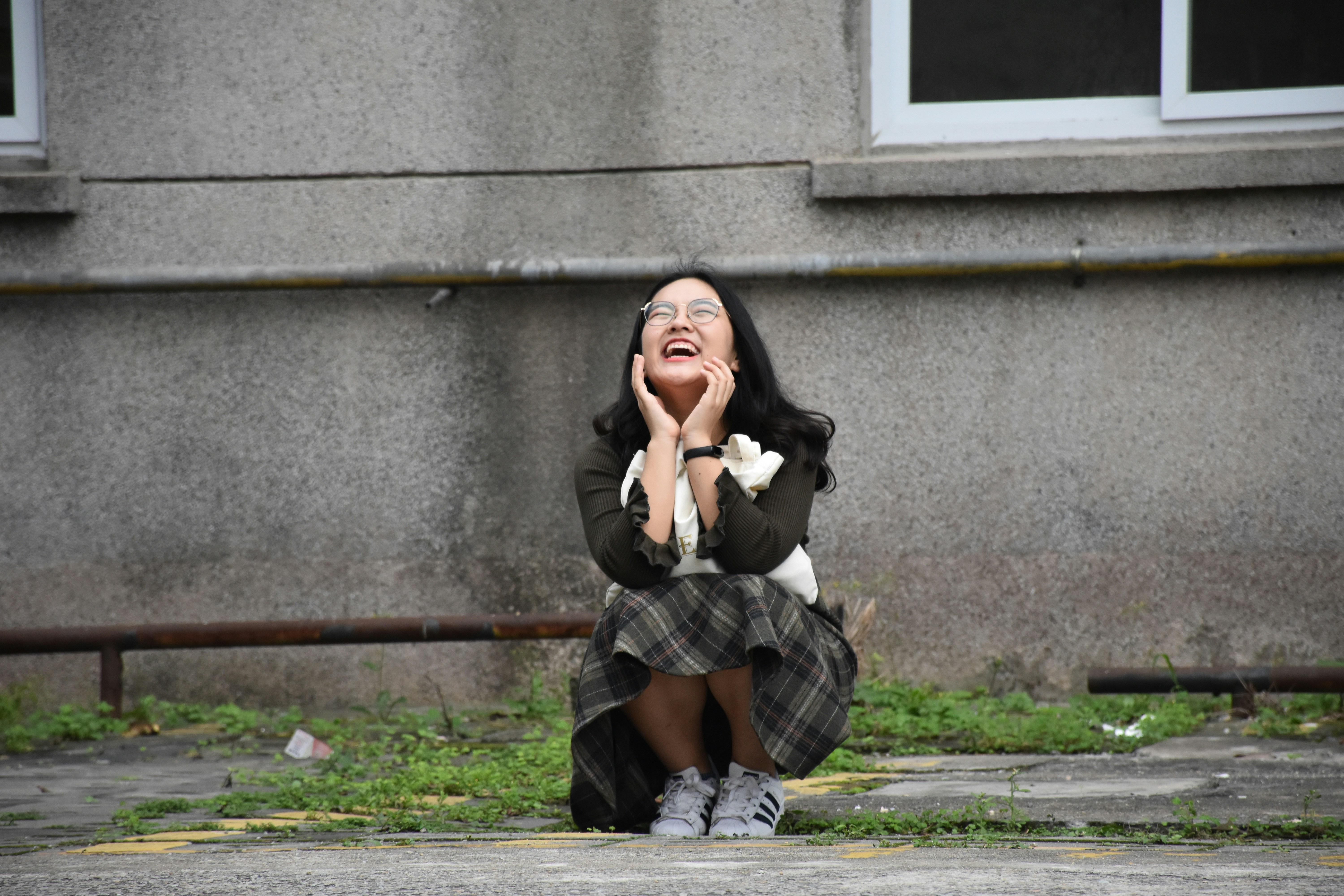 a woman sitting on the sidewalk