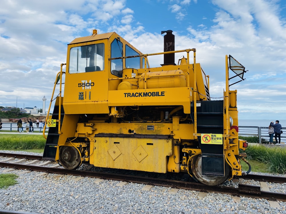 a yellow train on the tracks