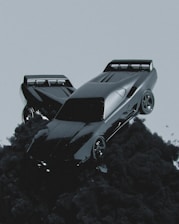 A sleek, futuristic car seems to be floating or emerging from dark, billowing smoke against a muted gray background. The car has a shiny, reflective surface and aerodynamic design, emphasizing speed and modernity.
