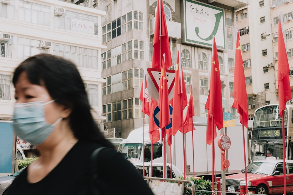 a person walking down a street with red and white flags