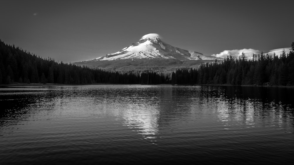 a mountain with snow on it by a lake