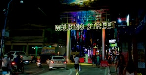 Lively street scene in Pattaya with neon signs and bustling nightlife crowd