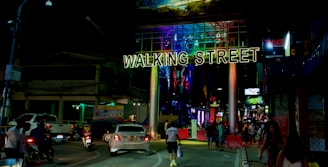 Lively street scene in Pattaya with neon signs and bustling nightlife crowd