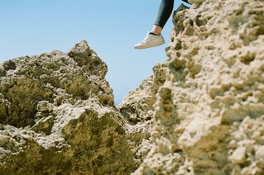 Le gambe di una persona su una roccia