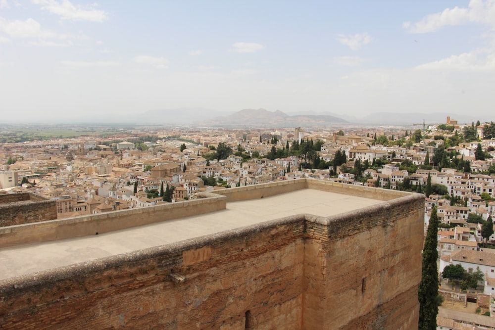 a large stone wall with a city in the background