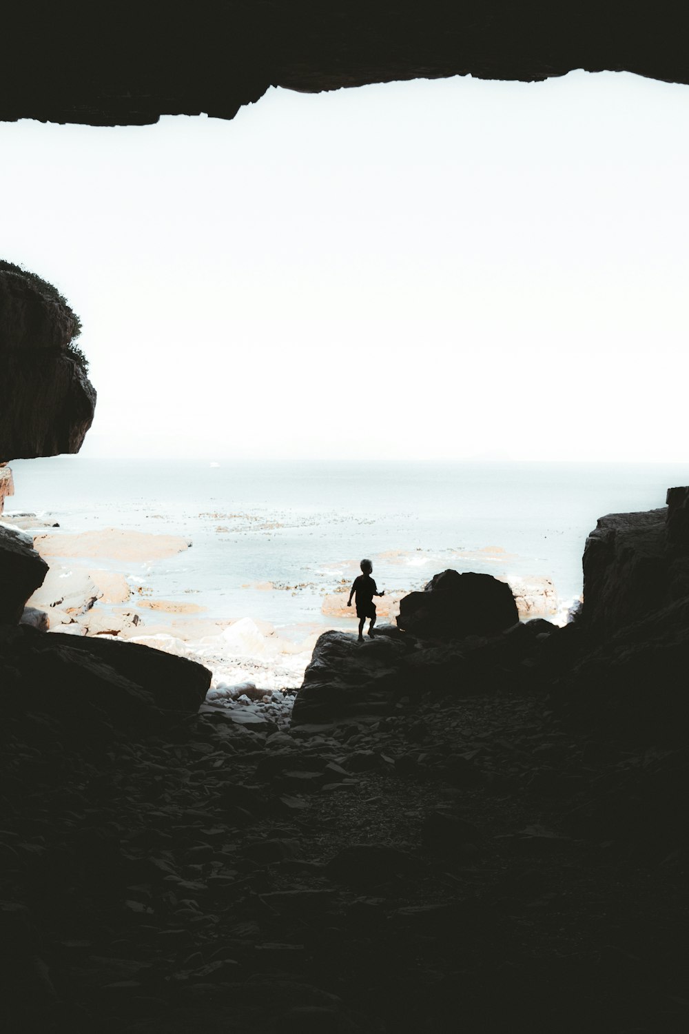a person standing on a rocky beach