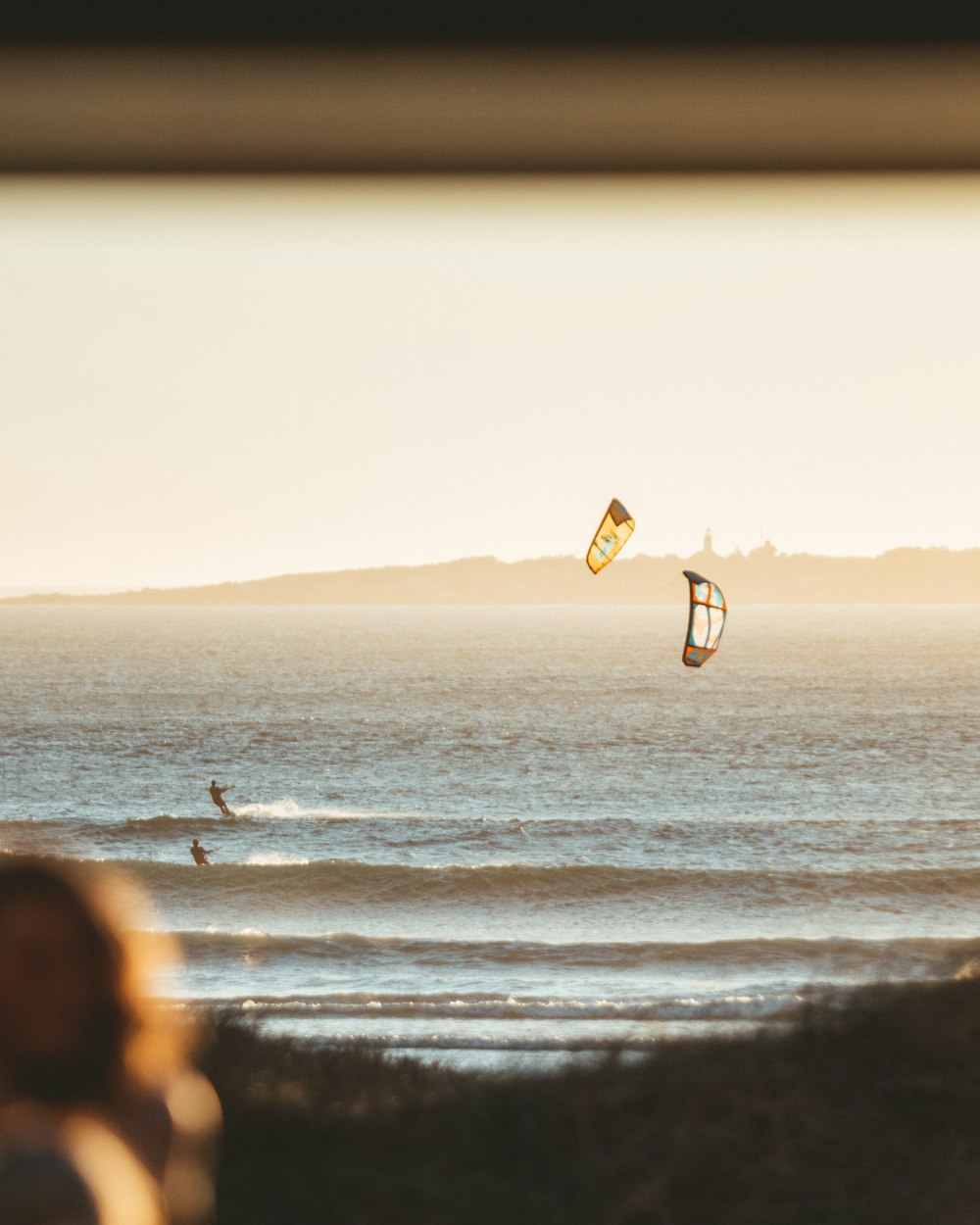 a person flying a kite on the beach