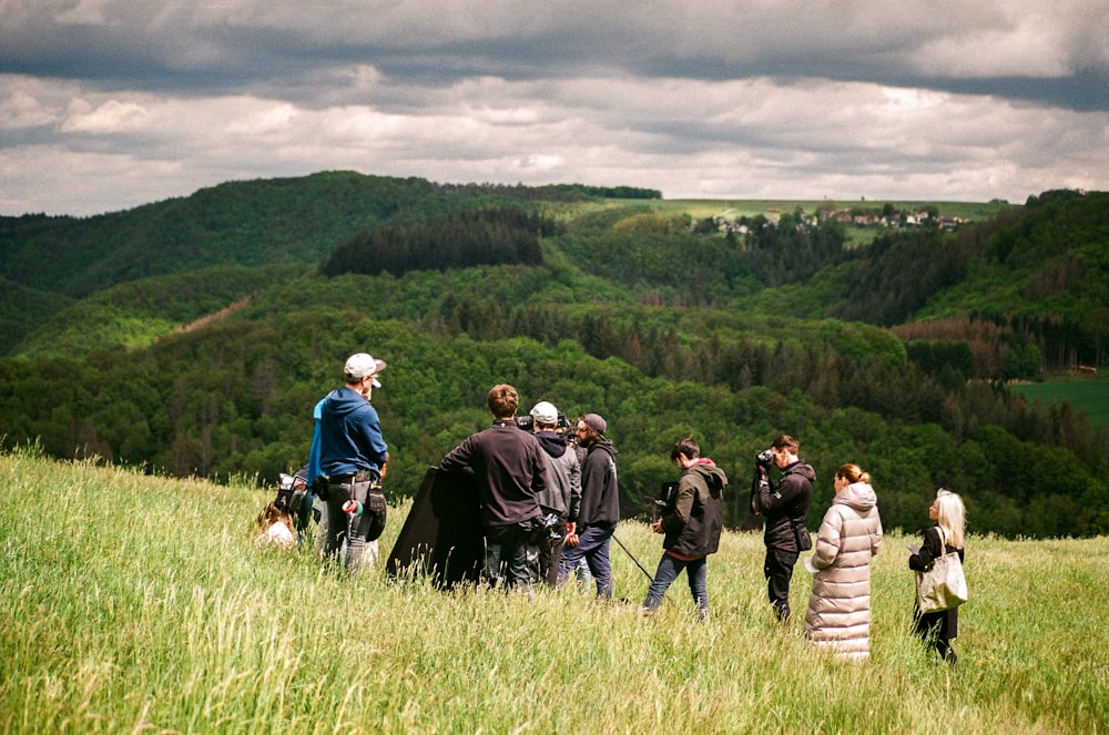 a group of people standing on a hill with dogs