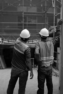 a couple of men wearing hard hats
