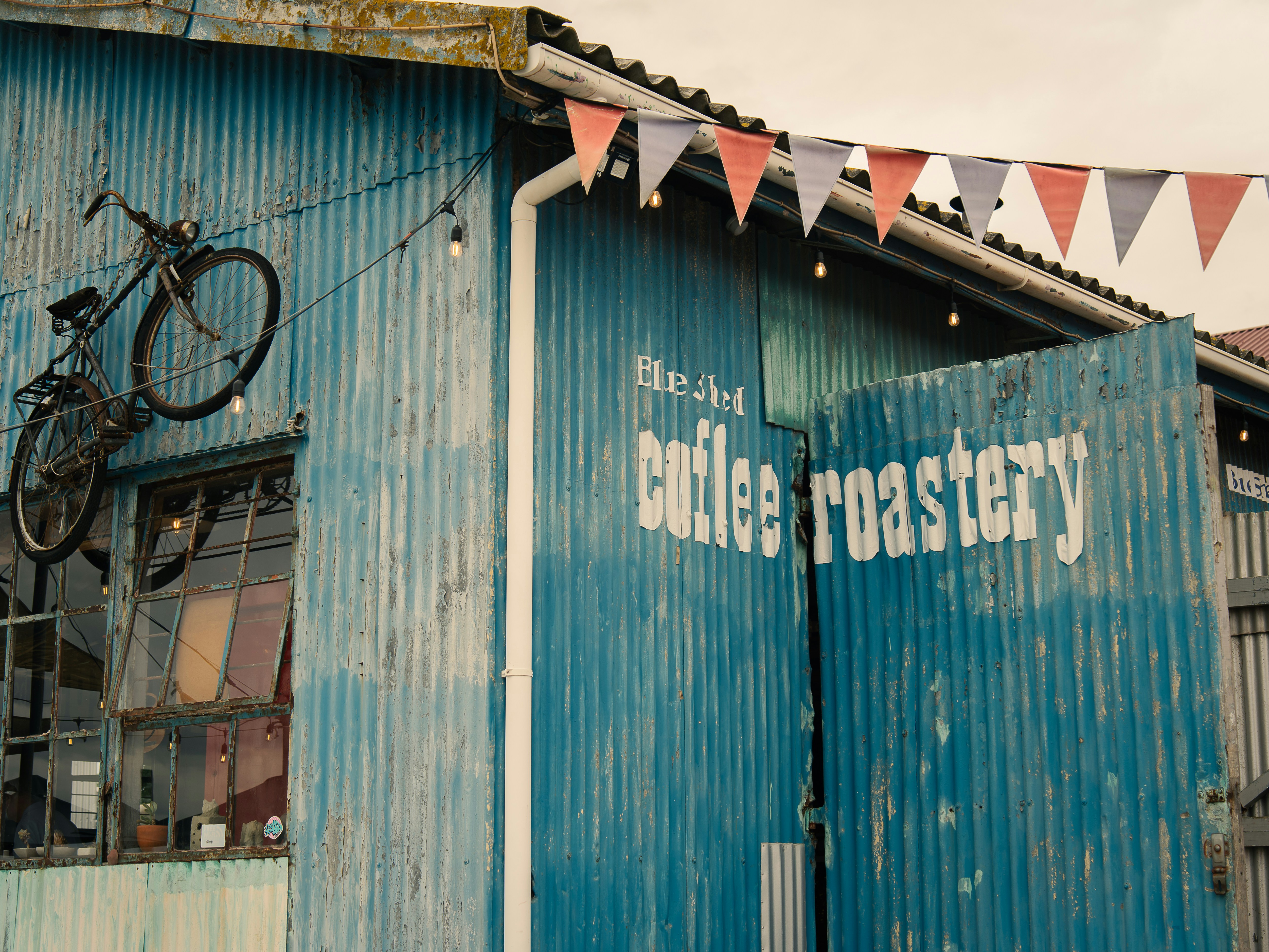 a blue building with a bicycle on the roof