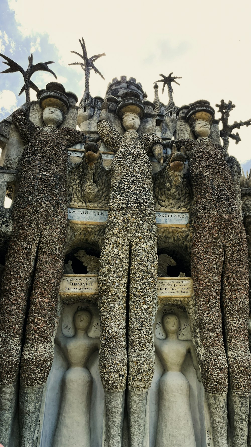 un gruppo di statue con Casa Batlló sullo sfondo
