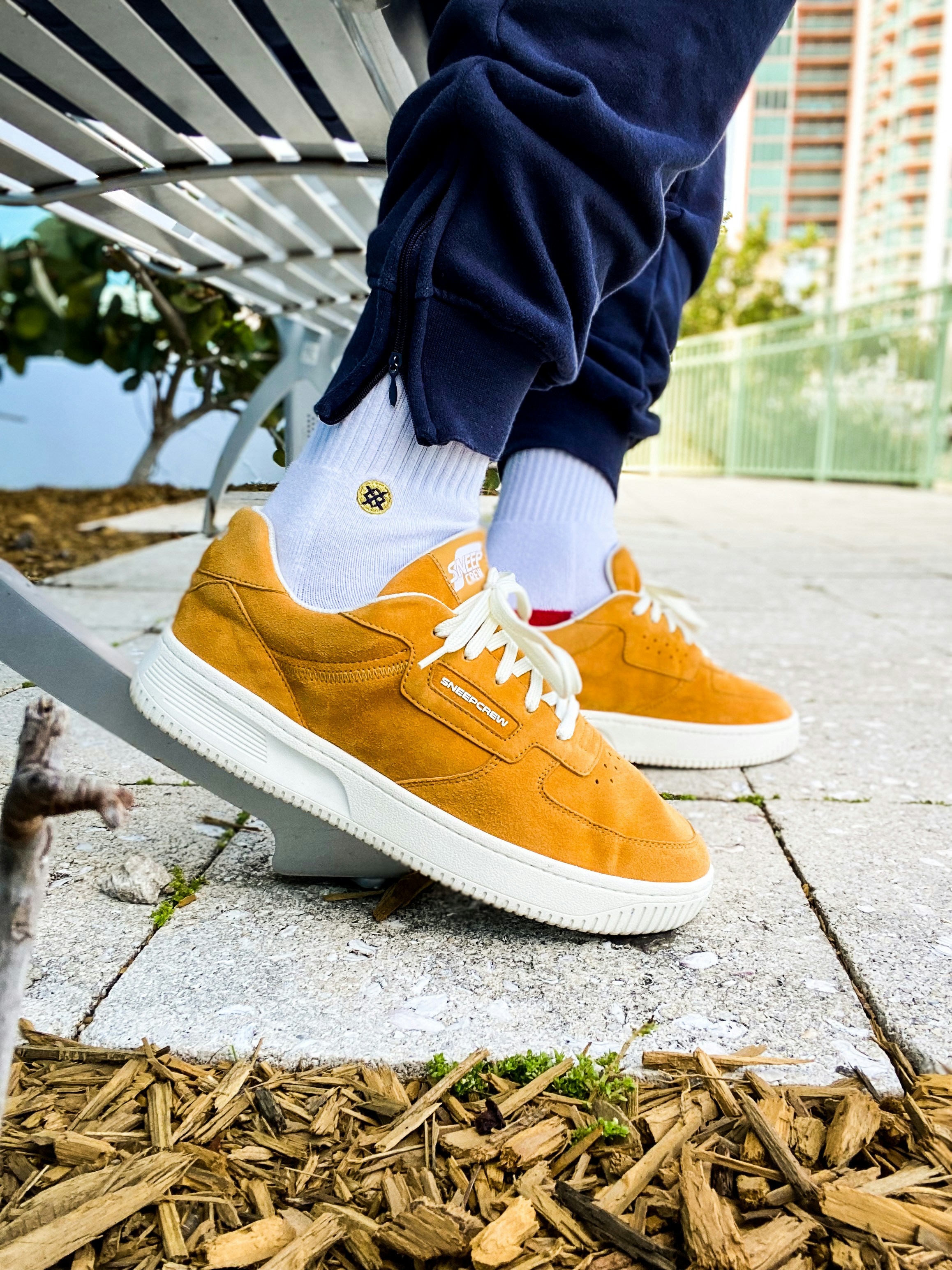 les jambes d’une personne dans une paire de chaussures sur un banc