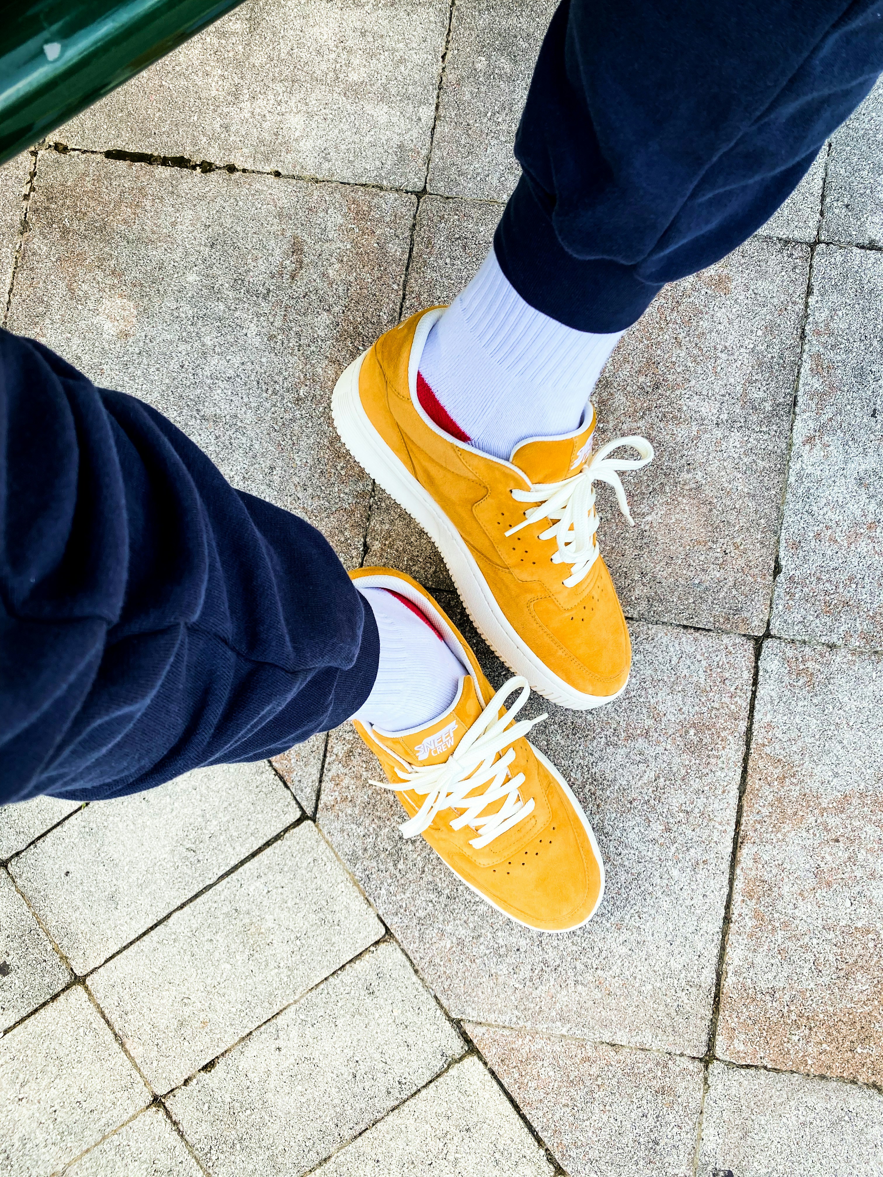 Les pieds d’une personne avec des chaussures orange et blanches photo