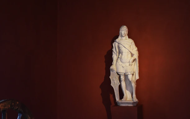A minimalist dark luxury visual featuring a Roman statue with a modern twist, symbolizing strength and clarity.