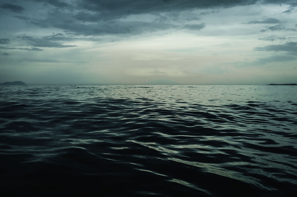 a body of water with clouds above it