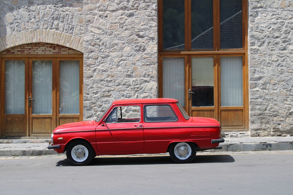 a red car parked in front of a building