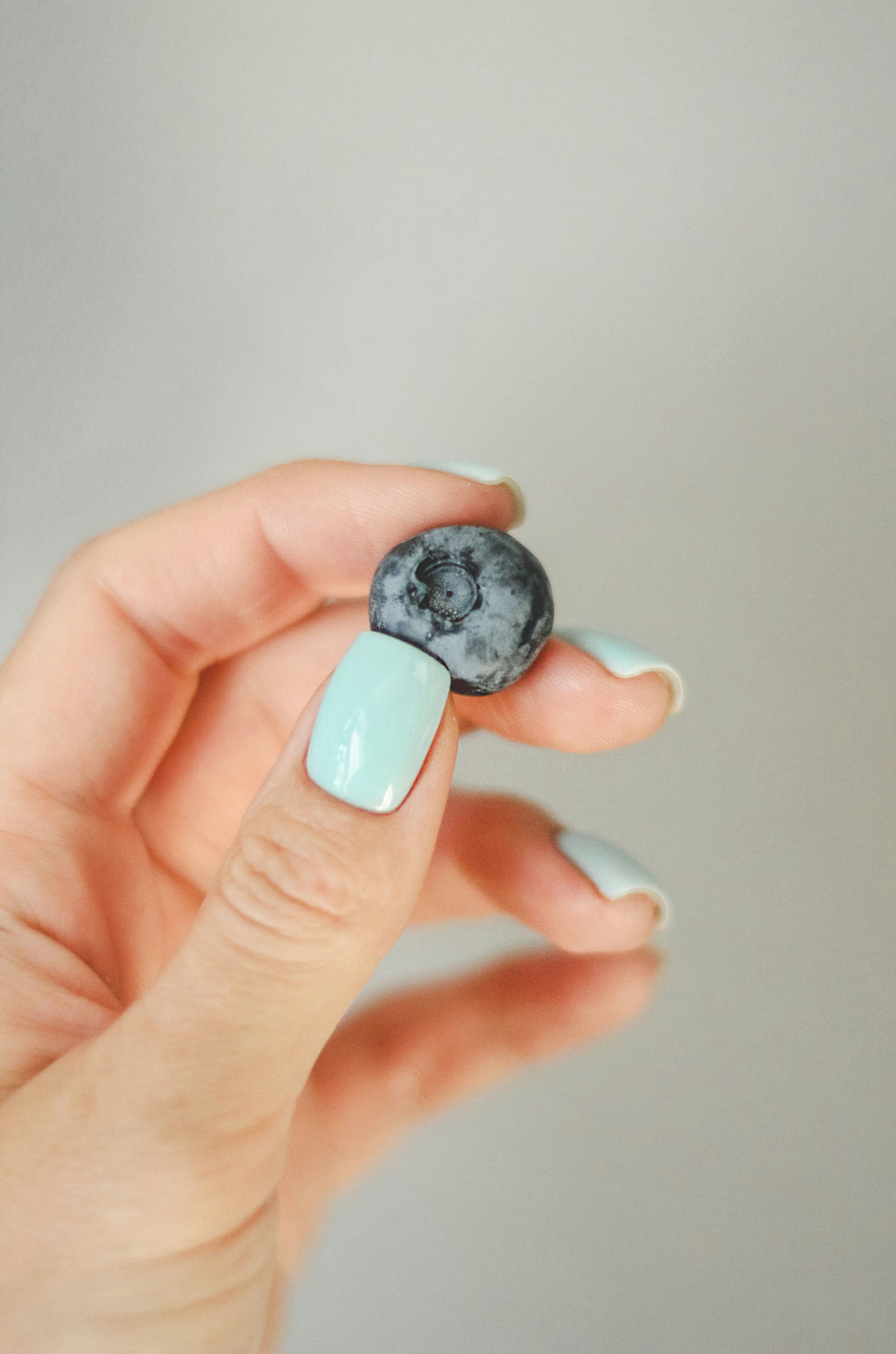 a hand holding a small blue and white object