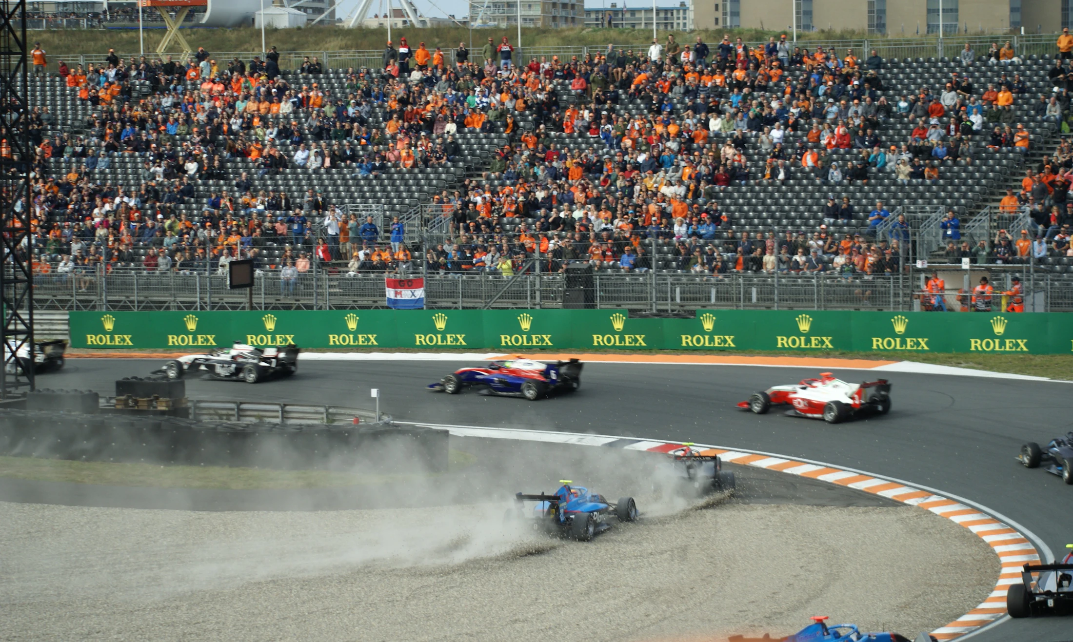 Formula 1 cars speeding past a packed grandstand