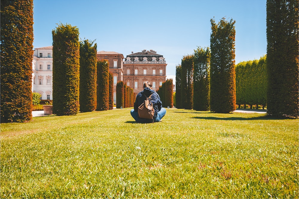 a person sitting on grass with a guitar