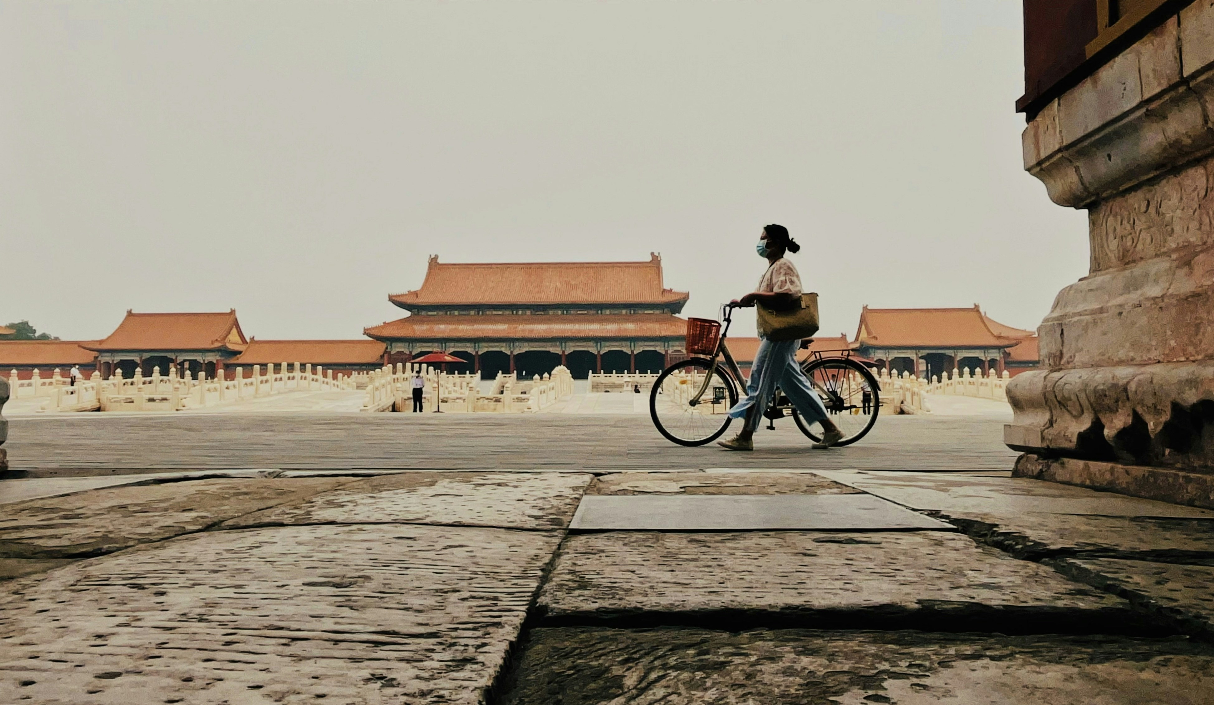 a person riding a bike in a courtyard with buildings in the background