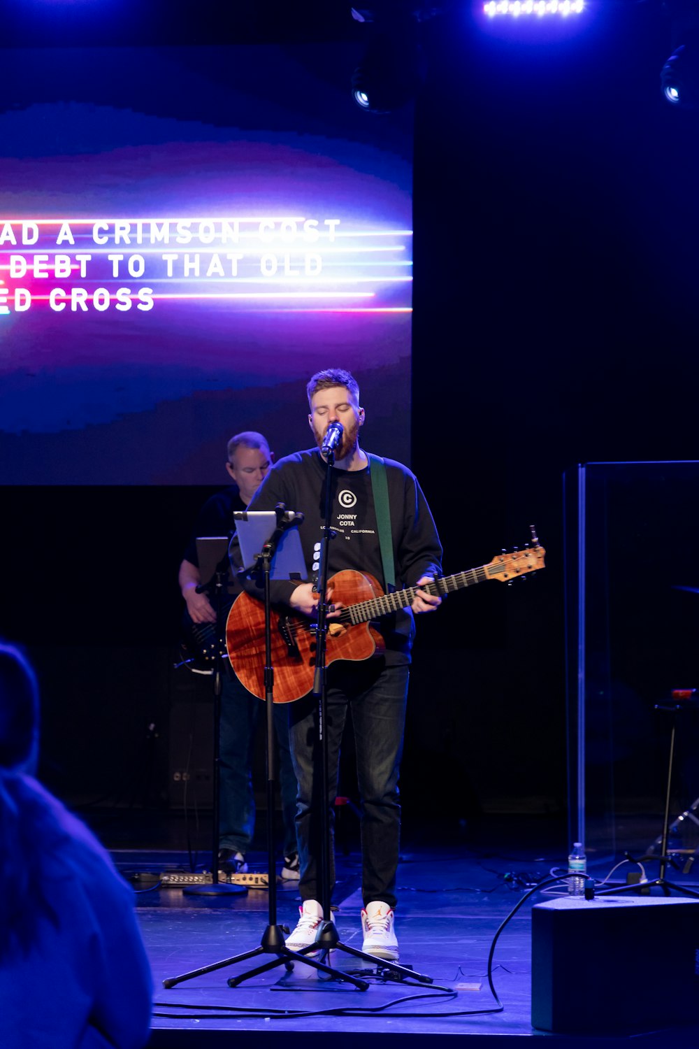 a couple of men on a stage with a guitar