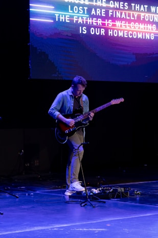 a man playing a guitar on a stage