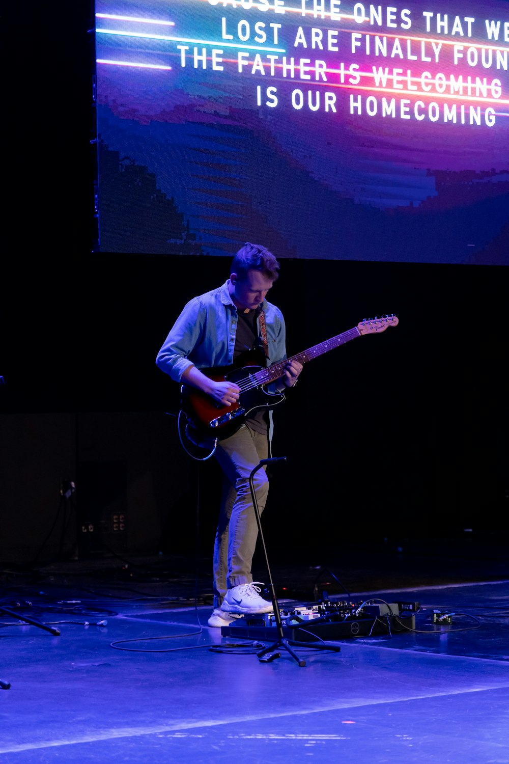 a man playing a guitar on a stage