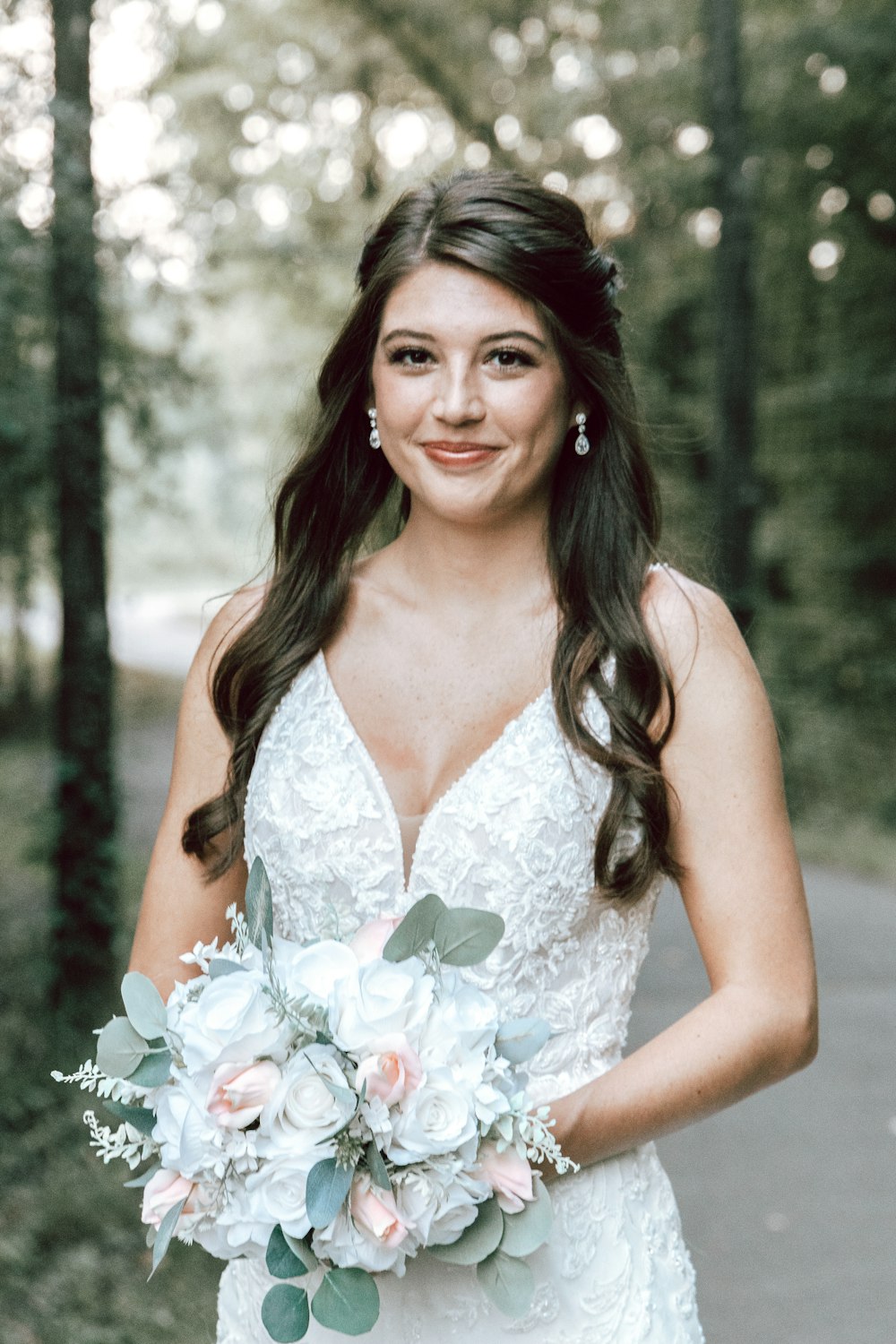 a woman in a white dress holding a bouquet of flowers