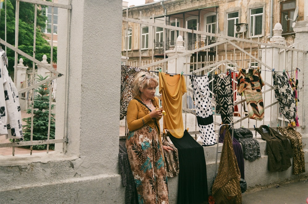 a person standing next to a row of clothes on a line