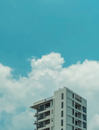 Modern apartment building with large balconies under a bright blue sky