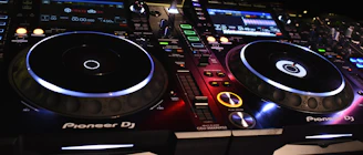 A sleek Pioneer DJ mixer set up in a vibrant club environment