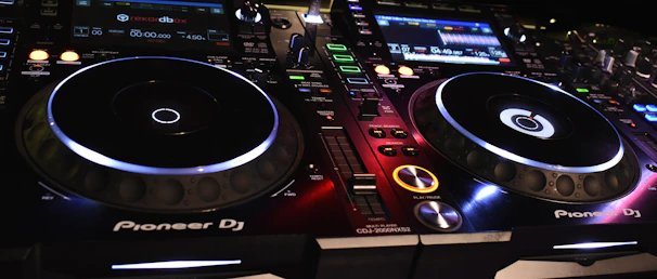 A sleek Pioneer DJ controller with colorful backlit buttons and jog wheels.