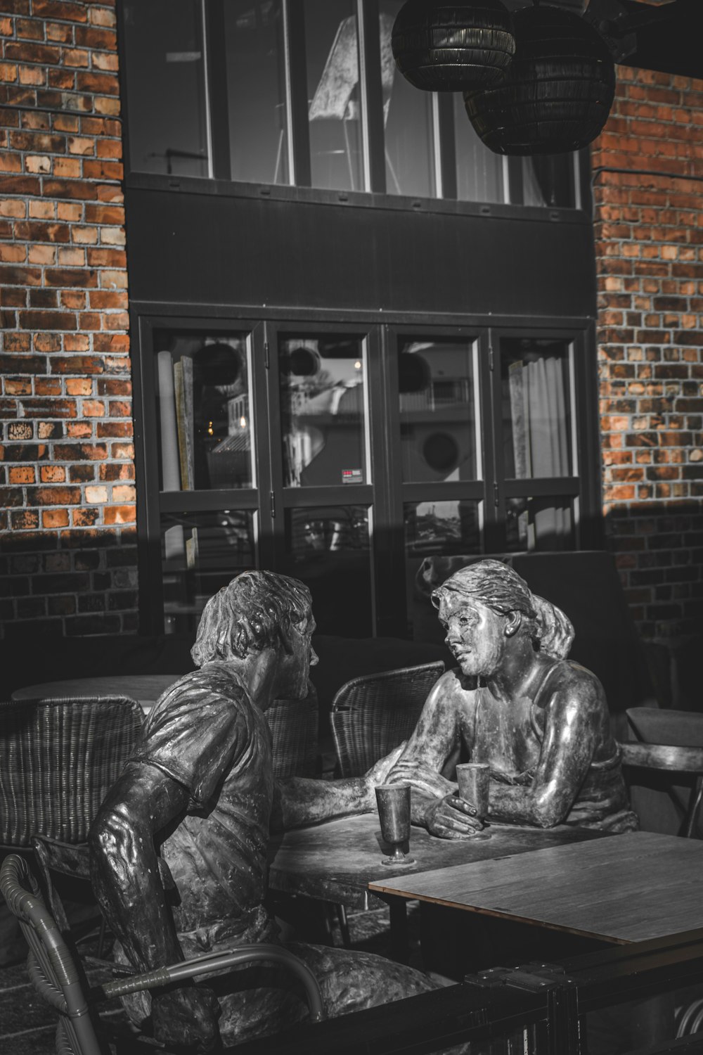 a couple of people sitting at a table looking at a window